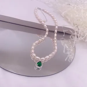 Detailansicht einer eleganten Reisperlenkette mit einem grünen Zirkonia-Anhänger