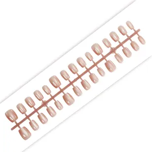 Close-up detail of glossy amber cat-eye press-on nails in nude pink short style