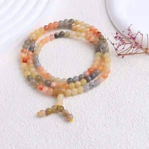 Detailansicht eines bunten Armbands aus natürlicher Goldsilber-Jade auf weißem Grund.