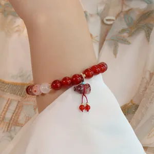 Detailansicht eines natürlichen Armbands aus roten Achatperlen mit traditionellem Anhänger