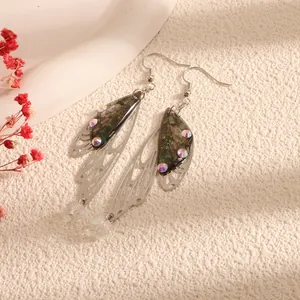Close-up of elegant silver butterfly wing earrings with iridescent rhinestones