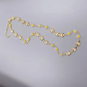 Dettaglio di alta qualità di una collana con ciondoli a margherita e farfalla dorata