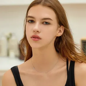 Κοντινό πλάνο ενός μινιμαλιστικού ασημένιου κολιέ με μενταγιόν αρχικού γράμματος