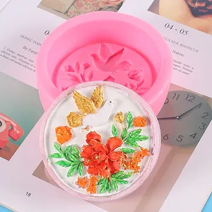 Detail view of circular pink silicone mold and finished bird floral relief craft