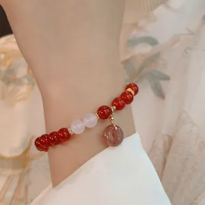 Nahaufnahme eines Armbands aus rotem Achat mit Jadenanhänger im orientalischen Stil