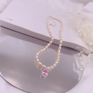 Detailaufnahme der Süßwasserperlenkette mit rosa tropfenförmigem Zirkon auf Spiegel