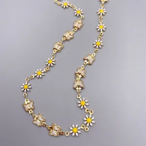 Vista dettagliata di un'elegante collana placcata in oro con margherite e farfalle.