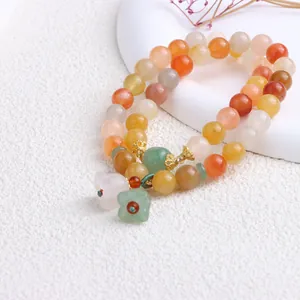 Detailansicht eines natürlichen Xinjiang Jin Si Jade Perlenarmbands mit Blumenanhängern