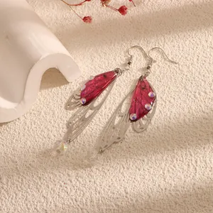 Close-up of elegant purple cicada wing earrings with hollow silver frame and crystal beads
