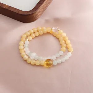 Macro detail of a double-loop bracelet with yellow jade beads and citrine crystal