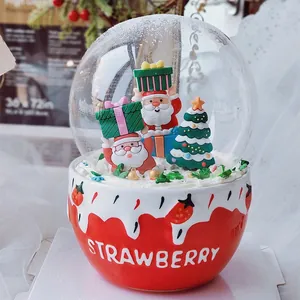 Décoration de gâteau de Noël avec le Père Noël et un sapin dans un dôme fraise rouge