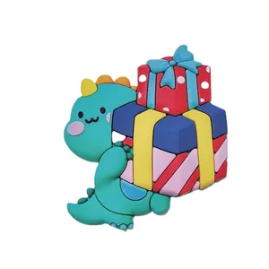 Cute green cartoon dinosaur cake topper holding colorful gift boxes for birthday decoration.