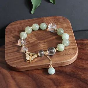 Detailansicht eines Armbands aus Birma-Jade und Kristall mit goldenem Schmetterling