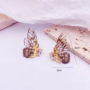 Vista detallada de los pendientes de alas de mariposa con medidas de 3 cm x 4 cm.