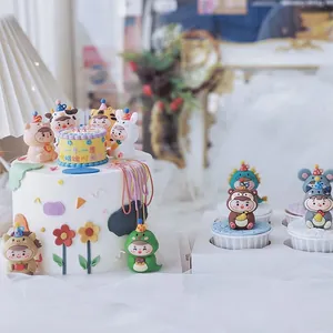 Dettaglio ravvicinato di graziose figurine di animali dello zodiaco per decorare torte.