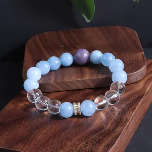 Detailansicht eines natürlichen Aquamarin- und Amethyst-Perlenarmbands auf Holztablett