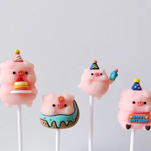 Macro view of four cute pink soft rubber pig cake toppers with birthday party hats