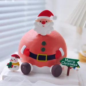 Close-up of Santa Claus and snowman cake topper ornaments with Merry Christmas sign