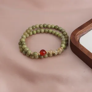Double-loop beaded bracelet featuring avocado green Alashan stones and a red carnelian accent