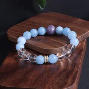 Detailaufnahme eines Armbands aus natürlichen Aquamarin- und Amethystperlen auf Holz