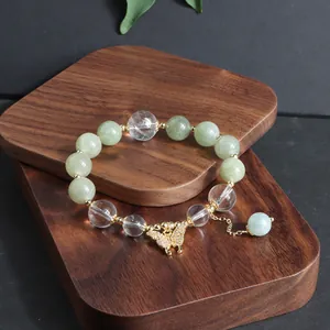 Nahaufnahme von Myanmar-Jade und Kristallarmband mit goldenem Schmetterlingsanhänger
