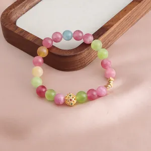 Nahaufnahme eines bunten Turmalin-Kristallarmbands mit einem goldenen Filigran-Anhänger