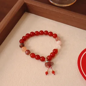 Nahaufnahme eines Armbands aus rotem Achat mit einem traditionellen Kürbis-Anhänger