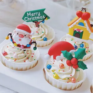 Détail de décorations de gâteau de Noël colorées en gomme souple posées sur des cupcakes.