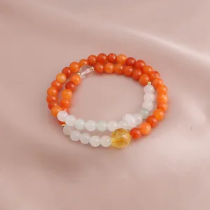 Detailed view of dual-strand beaded bracelet featuring orange jade and citrine crystal beads