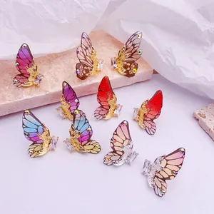 Primer plano detallado de varios pendientes de ala de mariposa en degradado con cristallen brillantes