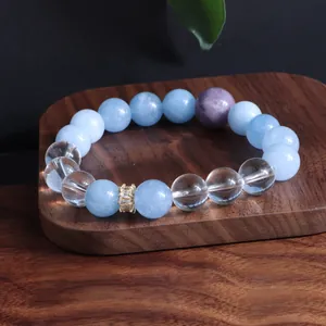 Nahaufnahme eines Armbands aus Aquamarin- und Amethystperlen auf Holz