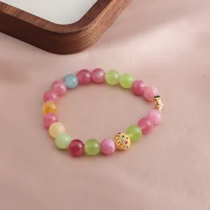 Nahaufnahme eines bunten Kristallperlenarmbands mit einem eleganten Goldanhänger