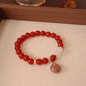 Detailansicht eines Armbands aus rotem Achat mit Jadeperlen und kleinem Steinanhänger.