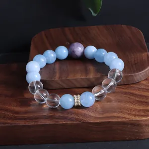 Detailaufnahme eines Perlenarmbands aus Aquamarin und Amethyst auf einem Holzständer