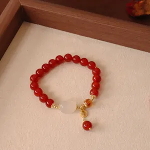 Exquisites Detail eines Armbands aus roten Achatperlen mit weißer Jade und Fu-Anhänger