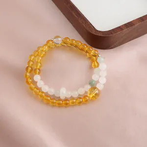 Detailed macro view of double-strand beaded bracelet with yellow citrine and white jade beads