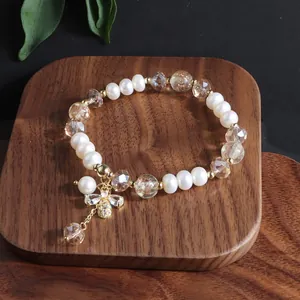 Detailansicht eines Armbands aus Süßwasserperlen und Kristallperlen mit Bienenanhänger.