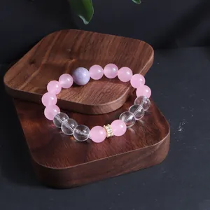 Detaillierte Ansicht eines Armbands aus Rosenquarz und Amethyst auf einem Holzständer