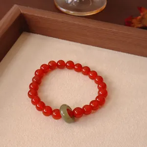 Detailansicht eines roten Karneol-Armbands mit einem grünen Jade-Ring-Anhänger