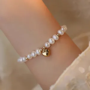 Vue détaillée d'un élégant bracelet en perles d'eau douce avec un pendentif cœur.