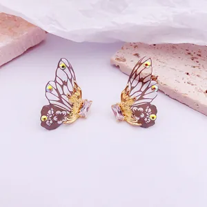 Vista macro de elegantes pendientes de ala de mariposa con cristales brillantes y toques dorados