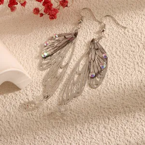 Close-up detail of silver simulation cicada wing earrings with iridescent rhinestones