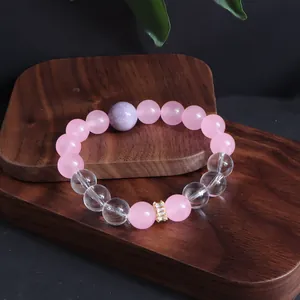 Detaillierte Ansicht eines rosa Kristallarmbands auf Holzständer
