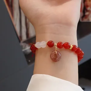 Detailansicht eines Armbands aus roten Achatperlen mit einem runden Donut-Anhänger