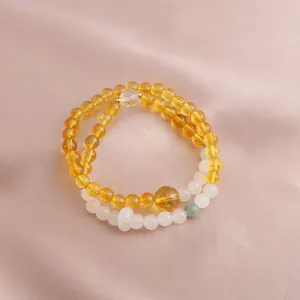 Detailed close-up of double-strand beaded bracelet with yellow citrine and white stones
