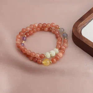 Close-up of a double-layer beaded bracelet featuring strawberry quartz and sunstone