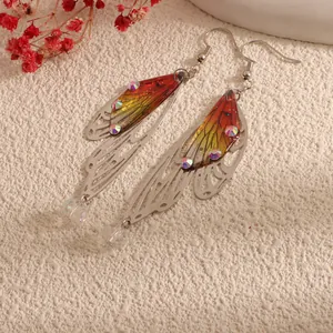 Detailed macro shot of elegant cicada wing drop earrings with colorful gradient and rhinestones.