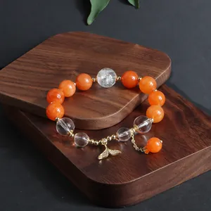 Detailansicht eines Armbands aus Sonnenstein und Quarz mit goldenem Fischschwanz-Anhänger.