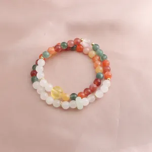 Close-up of multicolor beaded double strand bracelet with a jade-like ring detail.