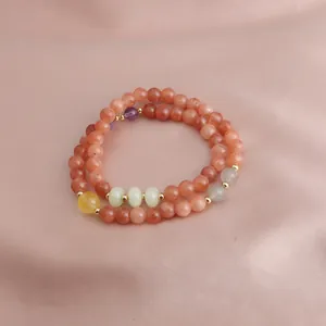 Detail of a double-loop bracelet with strawberry quartz, sunstone and amethyst beads